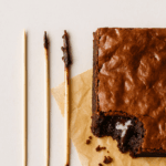Palito com migalhas de brownie indicando o ponto certo de cozimento.
