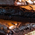 Close-up de brownies com textura molhadinha, casquinha brilhante por cima e interior denso e cremoso