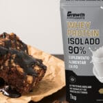 foto de brownie proteico com calda e whey Growth ao fundo