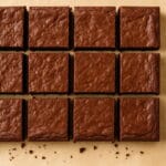 brownies em corte profissional com faca sobre papel manteiga