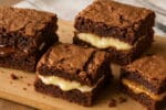 Brownies recheados com creme branco, brigadeiro e doce de leite, mostrando textura crocante e recheios