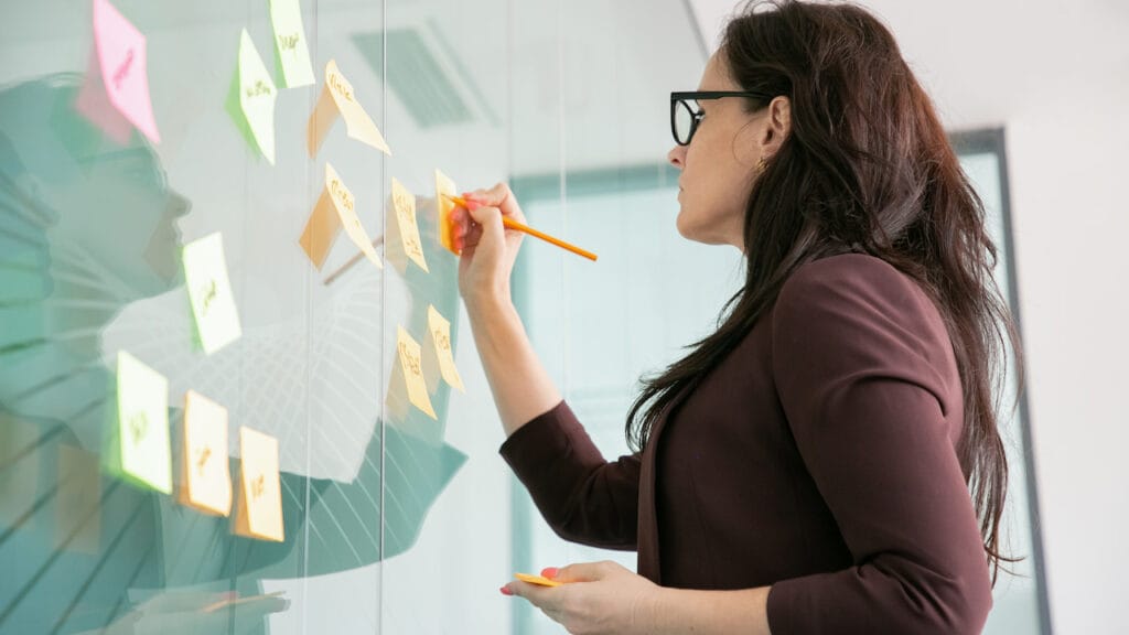 como-planejar-negocio-de-brownies mulher planejando em sticky notes