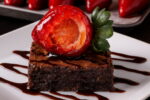 Para um visual irresistível, finalize o brownie com morango do amor e uma generosa calda de chocolate