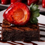 Para um visual irresistível, finalize o brownie com morango do amor e uma generosa calda de chocolate