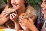 Amigas celebrando e compartilhando brownies, ilustrando o uso do doce como lembrancinha para festas e presentes.