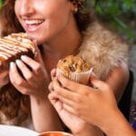 Amigas celebrando e compartilhando brownies, ilustrando o uso do doce como lembrancinha para festas e presentes.
