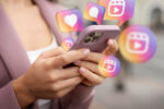 Mulher segurando um celular, representando o planejamento do marketing para vender doces no Instagram.