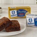 Brownies no prato com manteiga com sal ou sem sal no brownie em embalagens Batavo sobre bancada clara