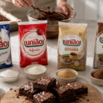 Embalagens de açúcar mostram qual açúcar usar no brownie, com bowls, chocolate e brownies na bancada.