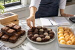 Bancada com brownies, brigadeiros e salgados, mostrando opções de comida para ganhar dinheiro por perfil.